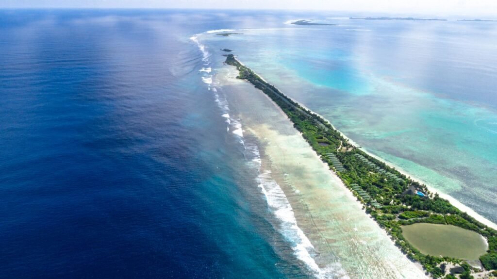 Breathtaking aerial view of Addu City in the Maldives featuring clear blue waters and vibrant coastline.